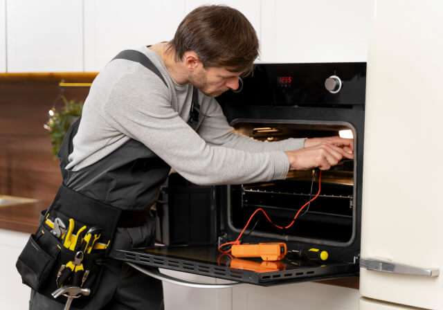 a man repairing the oven